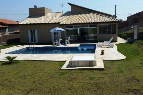 una casa con piscina en el patio en Casa com piscina no interior em condomínio fechado, en Quadra