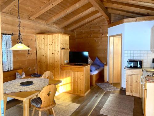 eine Küche und ein Esszimmer mit einem Tisch in einer Hütte in der Unterkunft Dammerer Hof in Ruhpolding