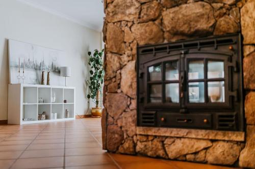a stone wall with a fireplace in a living room at A Nossa Casa in Castelejo