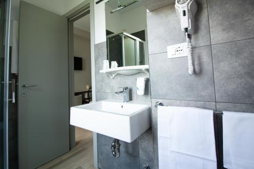 ein Badezimmer mit einem Waschbecken und einem Telefon an der Wand in der Unterkunft Hotel Europa in Termoli