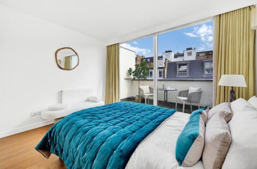 1 dormitorio con cama grande y ventana grande en 3 bdrm Notting Hill Mews house - 2 balconies en Londres