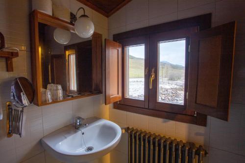 baño con lavabo y ventana en Casa Rural Anita, en Cabrillanes