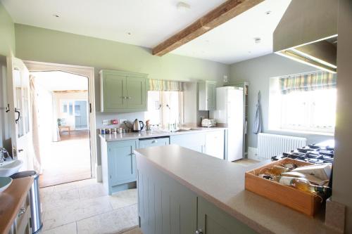 uma cozinha com armários verdes e uma bancada em An 8 Bed Luxury Farmhouse 