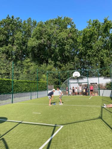 un grupo de personas de pie en una pista de tenis en Chant des Oiseaux ***, en Royan