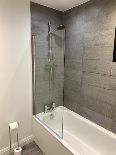 a bathroom with a shower and a bath tub at New large 2 bedroom apartment with private parking in Lea Town