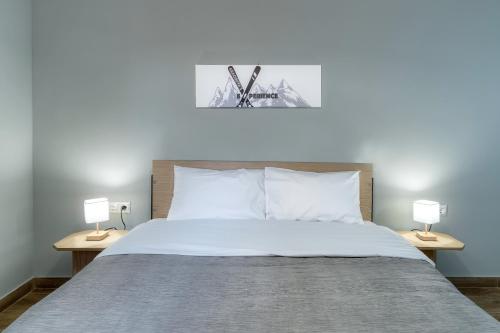 a bedroom with a large bed with two lamps at Arachova's Experience M2 in Arachova