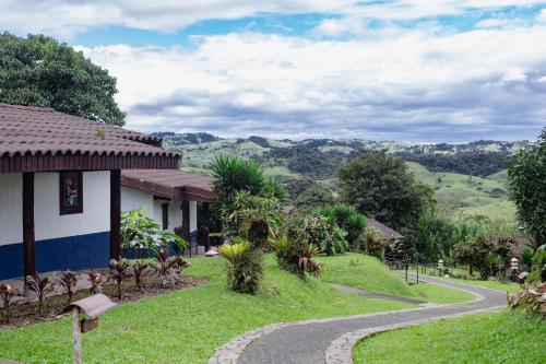 a house with a winding road next to a mountain at Villa Blanca Cloud Forest Hotel & Retreat in San Ramón