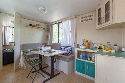 uma pequena cozinha com uma mesa e um balcão em Il Bungalow em Follonica