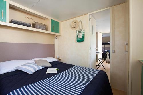 um quarto com uma cama com riscas azuis e brancas em Il Bungalow em Follonica