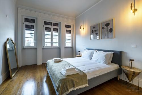 een slaapkamer met een bed met twee handdoeken erop bij Nomad's Family - 3BDR Charming Hideout Porto in Porto