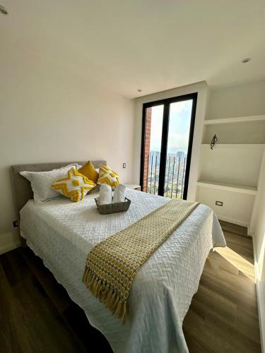 a bedroom with a bed with yellow pillows and a window at Apartamento 3 Habitaciones, Edificio Airali, Zona 10, Avellino in Guatemala