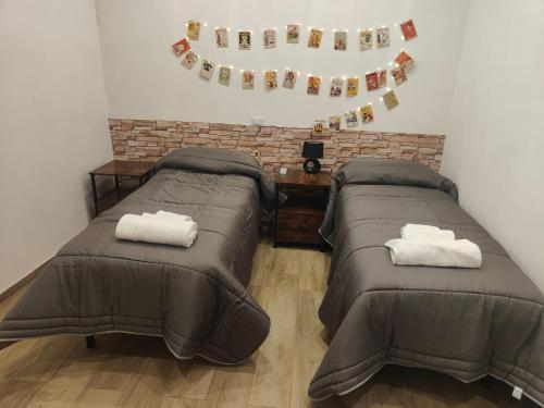 duas camas num quarto com bandeiras na parede em BELICE Holiday Rooms em Partanna