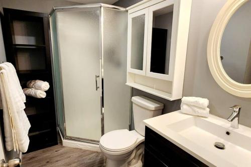 W łazience znajduje się prysznic, toaleta i umywalka. w obiekcie Guest Suite in Saint Hubert, bus to REM and Metro w mieście Longueuil