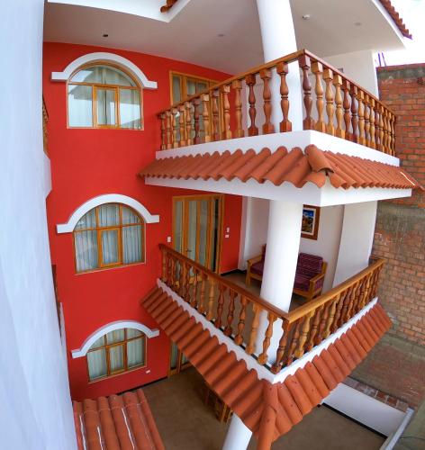an external view of a red building with stairs at Akilpo Home in Huaraz