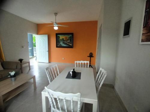 a dining room with a white table and chairs at Apartahotel MACADANA in Nagua