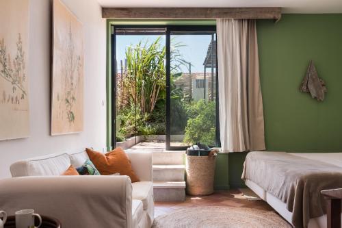 a living room with a couch and a window at Altanure - Almatere Food Forest Boutique Hotel in Tavira