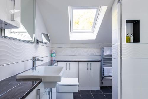 łazienka z umywalką, toaletą i oknem w obiekcie Fern View House over Loch Ness w mieście Inverness