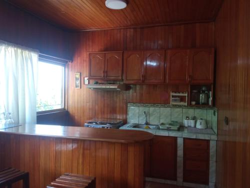 a kitchen with wooden cabinets and a counter top at DouchkaHouse in Puerto Maldonado