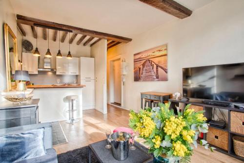 - une cuisine et un salon avec un vase de fleurs sur une table dans l'établissement La Casa Bella — Parking privé & vue sur l'abbaye, à Caen