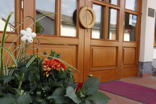 a wooden door with flowers in front of it at Fetzers Landhotel in Ingelheim am Rhein
