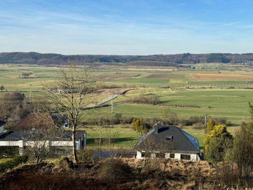 vistas a un campo con casas y árboles en Gîte des Hurlevents, en Bourglinster