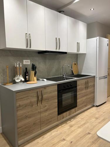 una cucina con elettrodomestici bianchi e armadietti in legno di Port View Apartment 2 a Durrës