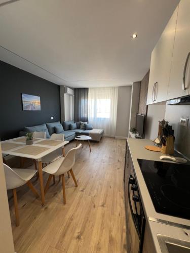 a kitchen and living room with a table and a couch at Port View Apartment 2 in Durrës