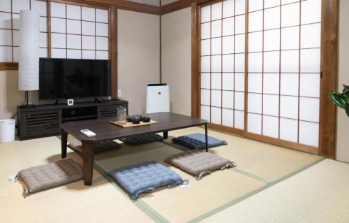 a living room with a table and a tv at GC01/生活してもOKな親切な部屋 /3 部屋/最大 6人入居/大阪城/3 ライン駅徒歩7分/清潔 in Osaka