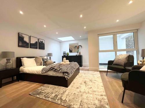 a bedroom with a bed and a couch and a chair at 1 Bed Apartment moments from Kings Cross Station! in London