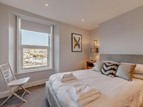 a bedroom with a bed and a chair and a window at 3 Bed in Brixham 78602 in Brixham