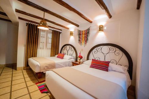 a hotel room with two beds in a room at Vilas Insight Hotel Machupicchu in Machu Picchu