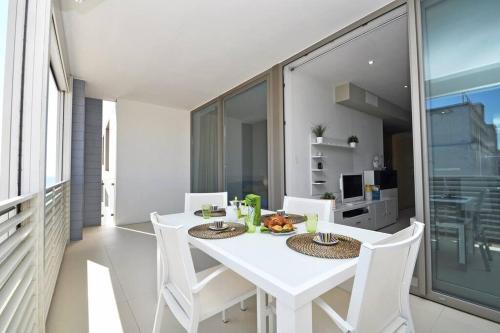 uma sala de jantar branca com uma mesa e cadeiras brancas em Suite Gallipoli con vista mare da 4 posti e wifi em Gallipoli