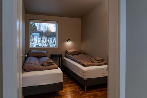 a small room with two beds and a window at Golden Circle Villa - Hot Tub & Sauna in Fludir
