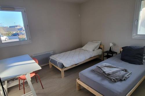 une chambre avec deux lits et une fenêtre dans l'établissement Appartement 60m2 RDC, à Vannes