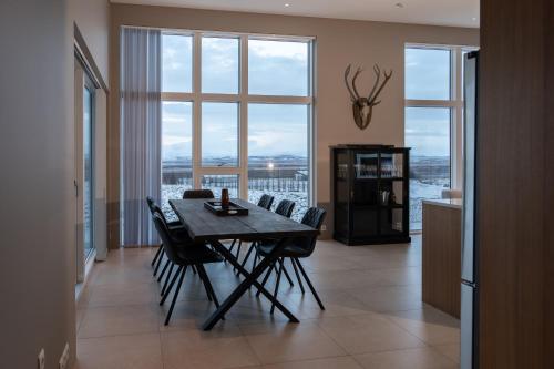 a dining room with a table and chairs and a large window at Golden Circle Villa - Hot Tub & Sauna in Fludir