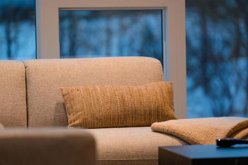 a brown couch with a pillow on it in a living room at Golden Circle Villa - Hot Tub & Sauna in Fludir