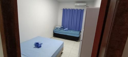um pequeno quarto com uma cama e um chuveiro azul em Casa aconchego da Camila em Foz do Iguaçu