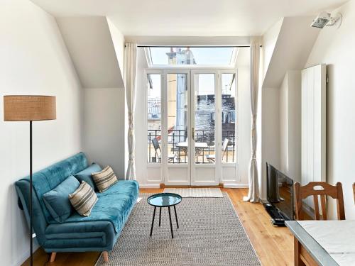 ein Wohnzimmer mit einem Sofa und einem Tisch in der Unterkunft Saint Sulpice Towers in Paris