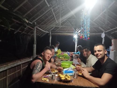 um grupo de pessoas sentadas à mesa a comer em Ransiwor Homestay em Kri