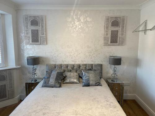 a bedroom with a large bed with two lamps at Botany Bay view Seaside Home in Broadstairs