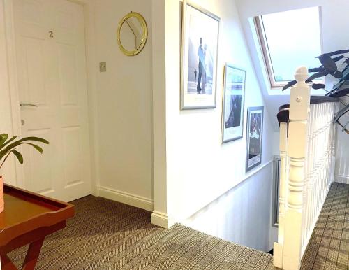 a hallway with a stairwell with a door and pictures on the wall at 26 Green Drive Inverness in Inshes