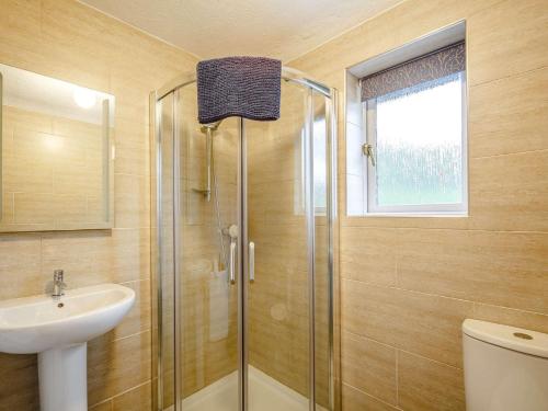 a bathroom with a glass shower and a sink at 3 Bed in Bala 88351 in Frongoch