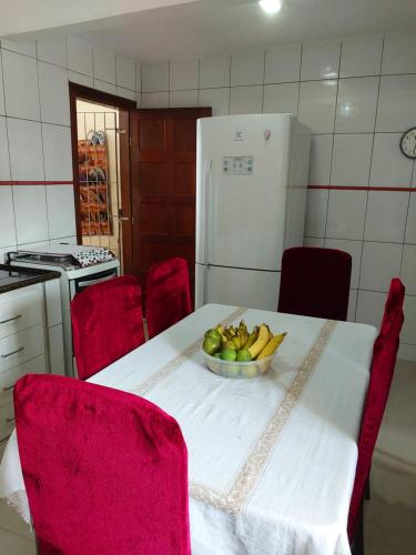 a kitchen with a table with a bowl of fruit on it at Casa com Piscina in Serra