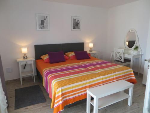 een slaapkamer met een bed met 2 nachtkastjes en 2 tafels bij Apartment Nava in Dubrovnik