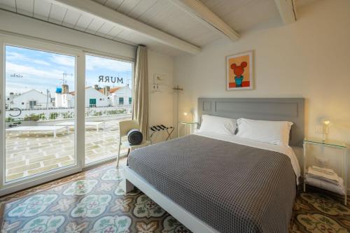 sypialnia z łóżkiem i dużym oknem w obiekcie Murr Luxury Rooms w mieście Noci
