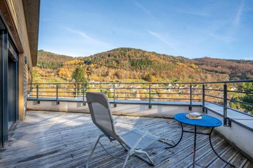 a patio with a table and a chair on a balcony at Villa calme avec vue 4 à 8 personnes - salle de sport in Saint-Amarin