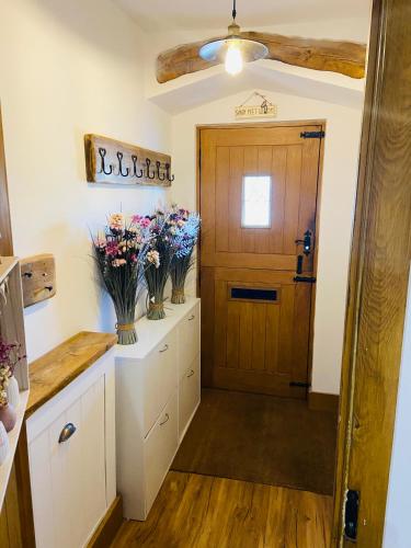 a kitchen with a door and vases of flowers at Botany Bay view Seaside Home in Broadstairs