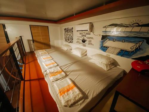 ein großes Bett in einem Zimmer mit einem Gemälde an der Wand in der Unterkunft TheBistroHouse - Loft Unit in San Vincente