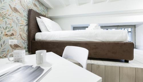 Un dormitorio con una cama grande con sábanas blancas. en Italianway - The B Village Standard, en Milán