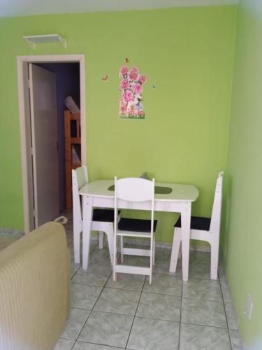 ein Esszimmer mit einem weißen Tisch und Stühlen in der Unterkunft Apartamento para temporada in Mongaguá